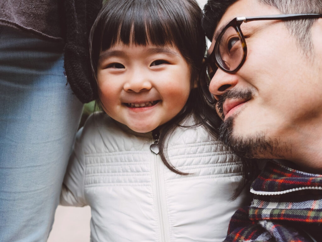 A young child smiling with her dad